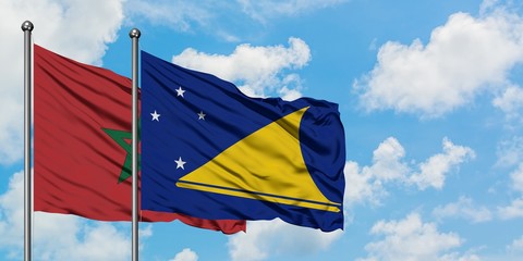 Morocco and Tokelau flag waving in the wind against white cloudy blue sky together. Diplomacy concept, international relations.