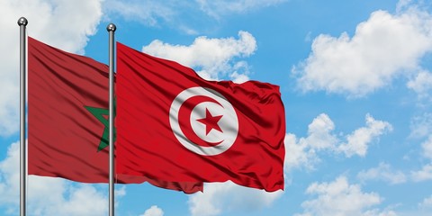 Morocco and Tunisia flag waving in the wind against white cloudy blue sky together. Diplomacy concept, international relations.