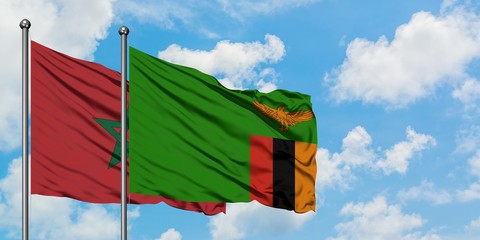 Morocco and Zambia flag waving in the wind against white cloudy blue sky together. Diplomacy concept, international relations.