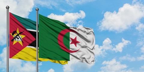 Mozambique and Algeria flag waving in the wind against white cloudy blue sky together. Diplomacy...