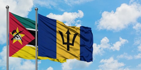 Mozambique and Barbados flag waving in the wind against white cloudy blue sky together. Diplomacy concept, international relations.