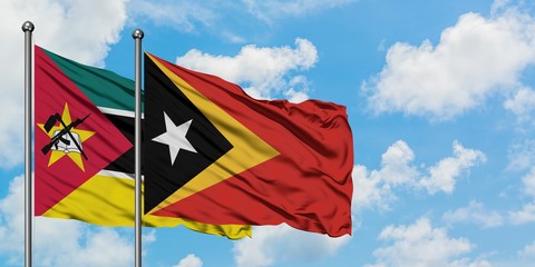Mozambique and East Timor flag waving in the wind against white cloudy blue sky together. Diplomacy concept, international relations.