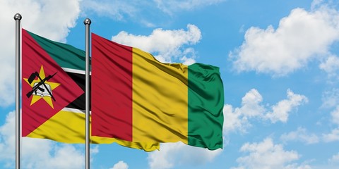 Mozambique and Guinea flag waving in the wind against white cloudy blue sky together. Diplomacy...