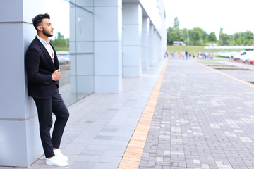 Arabic guy in business center stands smiling walking slow