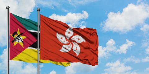 Mozambique and Hong Kong flag waving in the wind against white cloudy blue sky together. Diplomacy concept, international relations.