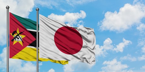 Mozambique and Japan flag waving in the wind against white cloudy blue sky together. Diplomacy concept, international relations.