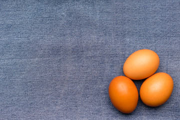 Brown chicken eggs on a blue denim.