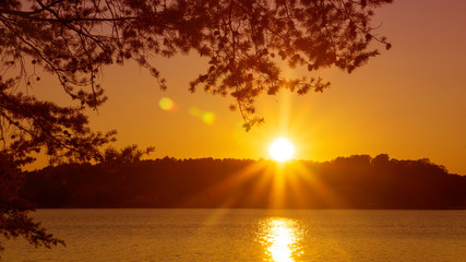 A scenic view of a sunset over a lake.