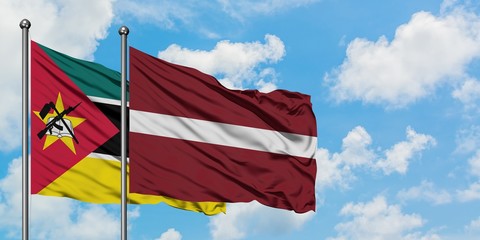 Mozambique and Latvia flag waving in the wind against white cloudy blue sky together. Diplomacy concept, international relations.