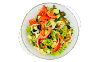 Vegetable salad in a glass dish, top view, close-up, isolated on a white background.