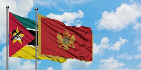 Mozambique and Montenegro flag waving in the wind against white cloudy blue sky together. Diplomacy...