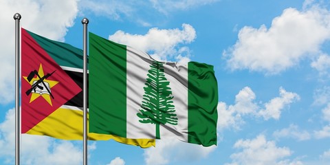 Mozambique and Norfolk Island flag waving in the wind against white cloudy blue sky together....