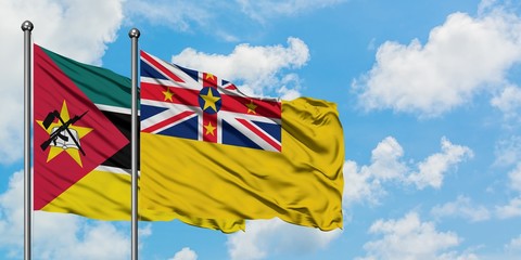 Mozambique and Niue flag waving in the wind against white cloudy blue sky together. Diplomacy concept, international relations.