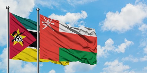 Mozambique and Oman flag waving in the wind against white cloudy blue sky together. Diplomacy concept, international relations.