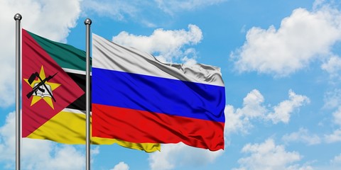 Mozambique and Russia flag waving in the wind against white cloudy blue sky together. Diplomacy...