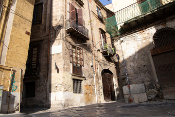 Fototapeta na wymiar Palermo, Italy, September 19, 2019: Confluence of several streets with old and poorly preserved buildings with wrought iron details on windows and balconies in Palermo