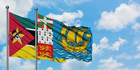 Mozambique and Saint Pierre And Miquelon flag waving in the wind against white cloudy blue sky together. Diplomacy concept, international relations.