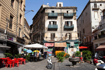 Palerme, Italie, 19 septembre 2019 : Place avec une fontaine, une moto garée, des plantes et des magasins autour avec des auvents et des façades de bâtiments en mauvais état