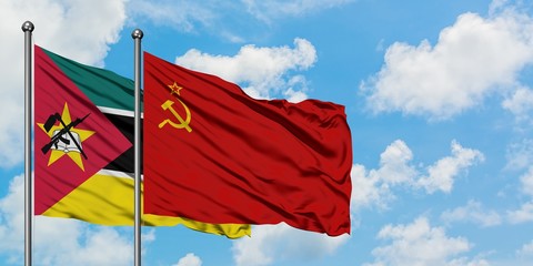 Mozambique and Soviet Union flag waving in the wind against white cloudy blue sky together....