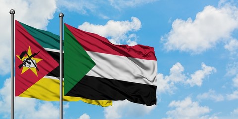 Mozambique and Sudan flag waving in the wind against white cloudy blue sky together. Diplomacy...