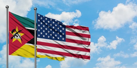 Mozambique and United States flag waving in the wind against white cloudy blue sky together. Diplomacy concept, international relations.