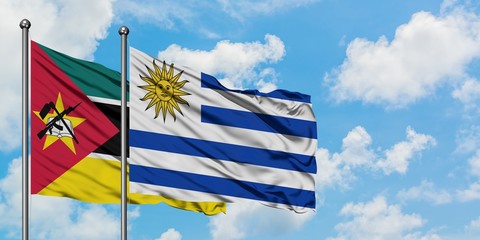 Mozambique and Uruguay flag waving in the wind against white cloudy blue sky together. Diplomacy concept, international relations.