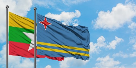 Myanmar and Aruba flag waving in the wind against white cloudy blue sky together. Diplomacy concept, international relations.