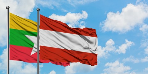 Myanmar and Austria flag waving in the wind against white cloudy blue sky together. Diplomacy concept, international relations.