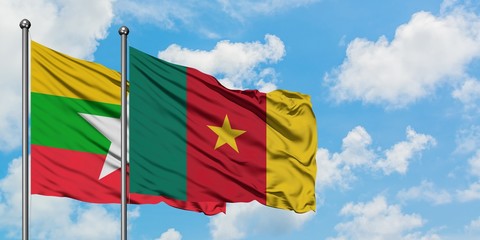 Myanmar and Cameroon flag waving in the wind against white cloudy blue sky together. Diplomacy...