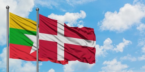 Myanmar and Denmark flag waving in the wind against white cloudy blue sky together. Diplomacy concept, international relations.