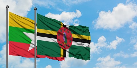 Myanmar and Dominica flag waving in the wind against white cloudy blue sky together. Diplomacy...