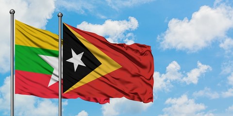 Myanmar and East Timor flag waving in the wind against white cloudy blue sky together. Diplomacy concept, international relations.
