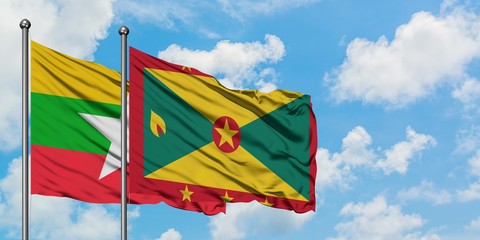 Myanmar and Grenada flag waving in the wind against white cloudy blue sky together. Diplomacy concept, international relations.
