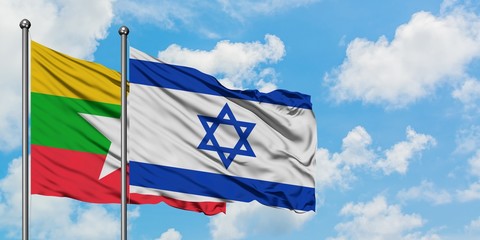 Myanmar and Israel flag waving in the wind against white cloudy blue sky together. Diplomacy concept, international relations.