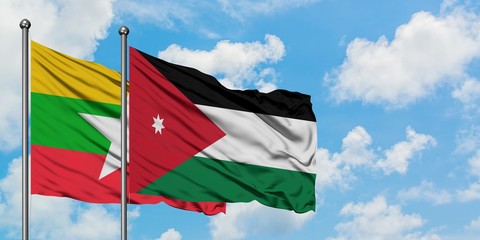 Myanmar and Jordan flag waving in the wind against white cloudy blue sky together. Diplomacy concept, international relations.
