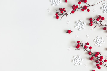 Christmas or winter composition. Snowflakes and red berries on gray background. Christmas, winter, new year concept. Flat lay, top view, copy space