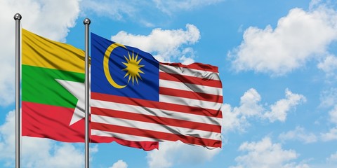 Myanmar and Malaysia flag waving in the wind against white cloudy blue sky together. Diplomacy concept, international relations.