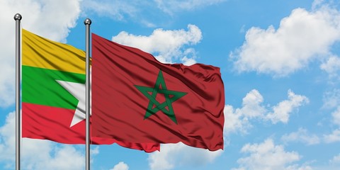 Myanmar and Morocco flag waving in the wind against white cloudy blue sky together. Diplomacy concept, international relations.
