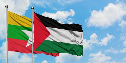 Myanmar and Palestine flag waving in the wind against white cloudy blue sky together. Diplomacy...