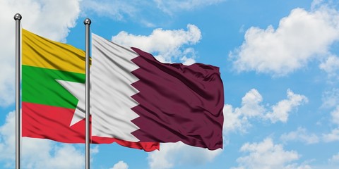 Myanmar and Qatar flag waving in the wind against white cloudy blue sky together. Diplomacy concept, international relations.