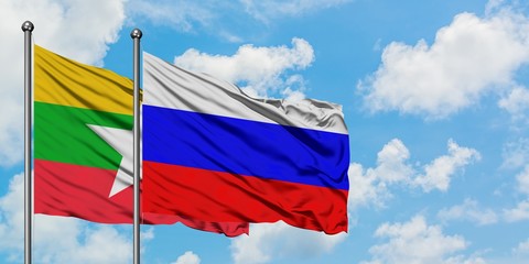 Myanmar and Russia flag waving in the wind against white cloudy blue sky together. Diplomacy concept, international relations.