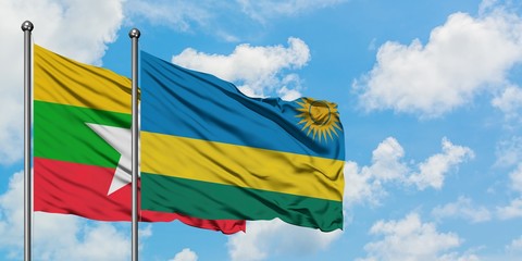 Myanmar and Rwanda flag waving in the wind against white cloudy blue sky together. Diplomacy concept, international relations.