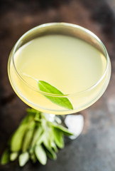 Tasty cocktail with limoncello and sage leaves on the rustic background. Shallow depth of field. Selective focus.