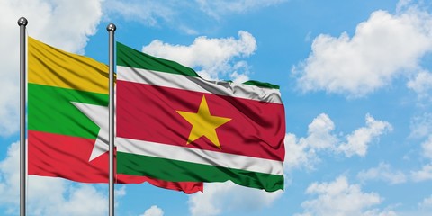 Myanmar and Suriname flag waving in the wind against white cloudy blue sky together. Diplomacy concept, international relations.