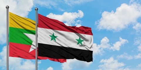 Myanmar and Syria flag waving in the wind against white cloudy blue sky together. Diplomacy...
