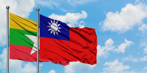 Myanmar and Taiwan flag waving in the wind against white cloudy blue sky together. Diplomacy concept, international relations.