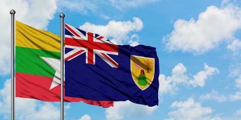 Myanmar and Turks And Caicos Islands flag waving in the wind against white cloudy blue sky together. Diplomacy concept, international relations.
