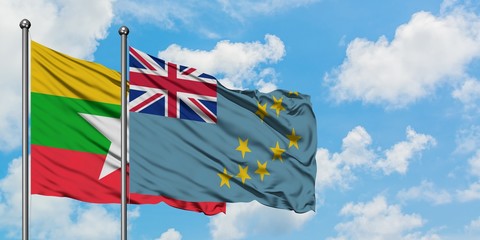 Myanmar and Tuvalu flag waving in the wind against white cloudy blue sky together. Diplomacy...