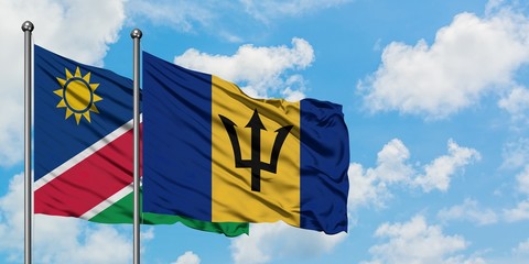 Namibia and Barbados flag waving in the wind against white cloudy blue sky together. Diplomacy concept, international relations.