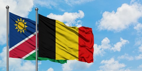 Namibia and Belgium flag waving in the wind against white cloudy blue sky together. Diplomacy concept, international relations.